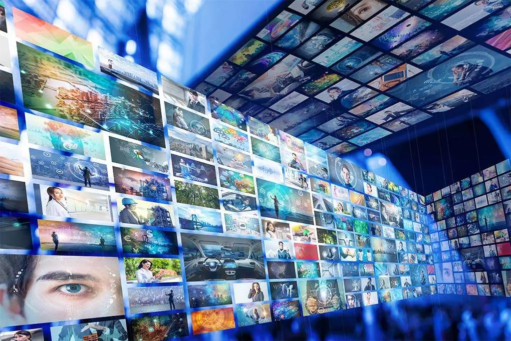A curved wall of video screens displaying dozens of images